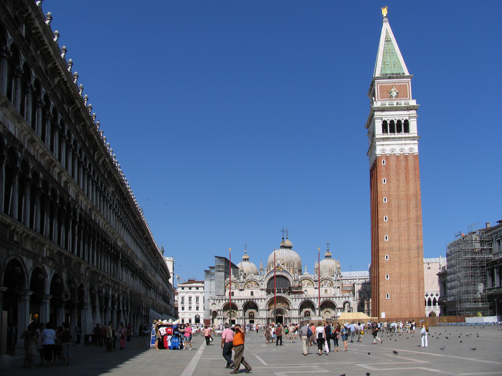 I stand at one end of the Piazza San Marco. In the shade, the air holds the crispness of late March. I know the sun will bring warmth. The intricate buildings loom, curved archways and stone facades iconic in their design. The eye is drawn towards the opposite end of the Piazza. The Byzantine domes and gilded mosaics of Saint Mark's Basilica reflect the late morning sunlight. Into the sky rises the Campanile, its white loggia tying it to is surroundings nearly as much as its red brick bulk separates it. The calmness of the morning has awakened to the beginnings of a crowd, enthused by the appearance of water from the coming Acqua Alta. Couples and families dance with pigeons, pose for photos, embrace and kiss. I am alone. The next track starts on my iPod: Bob Dylan, a statistically probability even out of the 5,800 songs held there. I had been deceiving myself with how miserable I’ve become. The previous year was a blur of work, stress, and boredom. An aimless boredom caused by a lack of direction and for the first time in my life, lack of a goal. Always a driven person, I reached the pinnacle of my chosen career before I was 30. My first novel had been a success (as much as any are in these digital days). The transition to freelance writer had been surprisingly smooth, and had become comfortably lucrative. Yet, it wasn’t enough. I was at a turning point. The previous two weeks had been spent with my father, driving around central Europe in a trip we’d discussed for the better part of a decade. It was brilliant, but my brain was still tied to home and work and all the stress therein. Minutes earlier I had left a dear friend, who by luck and chance I’d been able to meet in Venice. The first time we’d seen each other in nearly a year. She, and her travelling companions, had arraigned a gondola ride. I was to meet them after. In this brief moment, I was alone with my thoughts. In hindsight, I can see all the pieces in place for what would happen next. At the time, I had no idea the epiphany that was about to strike. As Bob started to growl his way into the first verse, a calmness came over me. My senses conspired to shock my brain into a new understanding. The view of the Piazza, the Basilica, the Campanile, the salty smells, the sounds of Venice filtering past the music, the power of the sun as I stepped out of the shade, all combined into one, simple thought: “This is the life.” This basic, obvious, simplistic sentence reacted like a catalyst in my weary brain, rapidly leading more thoughts. “This is the life. I should do this more.” “Why don’t I do this more?” My mind ticked through all the potential answers to that question, and couldn’t come up with any negative answers. I’d built a career that was flexible enough to be done anywhere. My income and expenditures were such that I could, if I was careful, do my job from elsewhere, fairly often. In that moment, I knew what the next stage of my life would be, and I was standing in it. I am an explorer. I need to see the world. Experience people, places, and things others write and have written about. What want in life is to go where I can’t read the signs, and were I’m the one with the strange accent. I am a bald nomad, and these are my adventures.